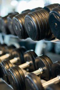 Close-up view of black dumbbells neatly arranged on a rack in a gym.